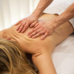 Kobieta leżąca na łóżku do masażu poddawana masażowi klasycznemu