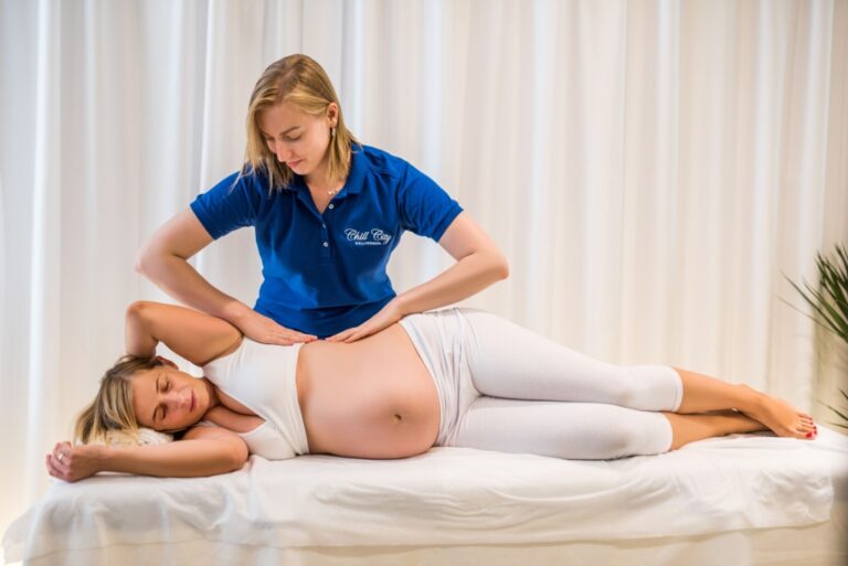 Kobieta w ciąży masowana przez terapeutkę SPA