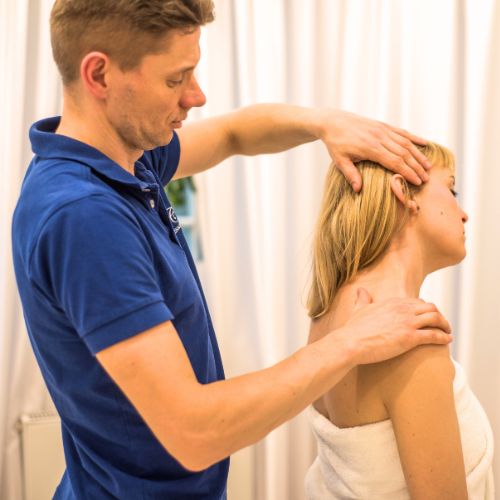 Physiotherapist performing a neck and shoulder treatment on a patient in a serene spa setting